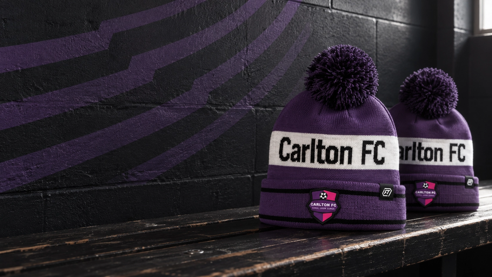 Purple Carlton FC bobble hats with club crests and small FT woven tabs on a changing-room bench