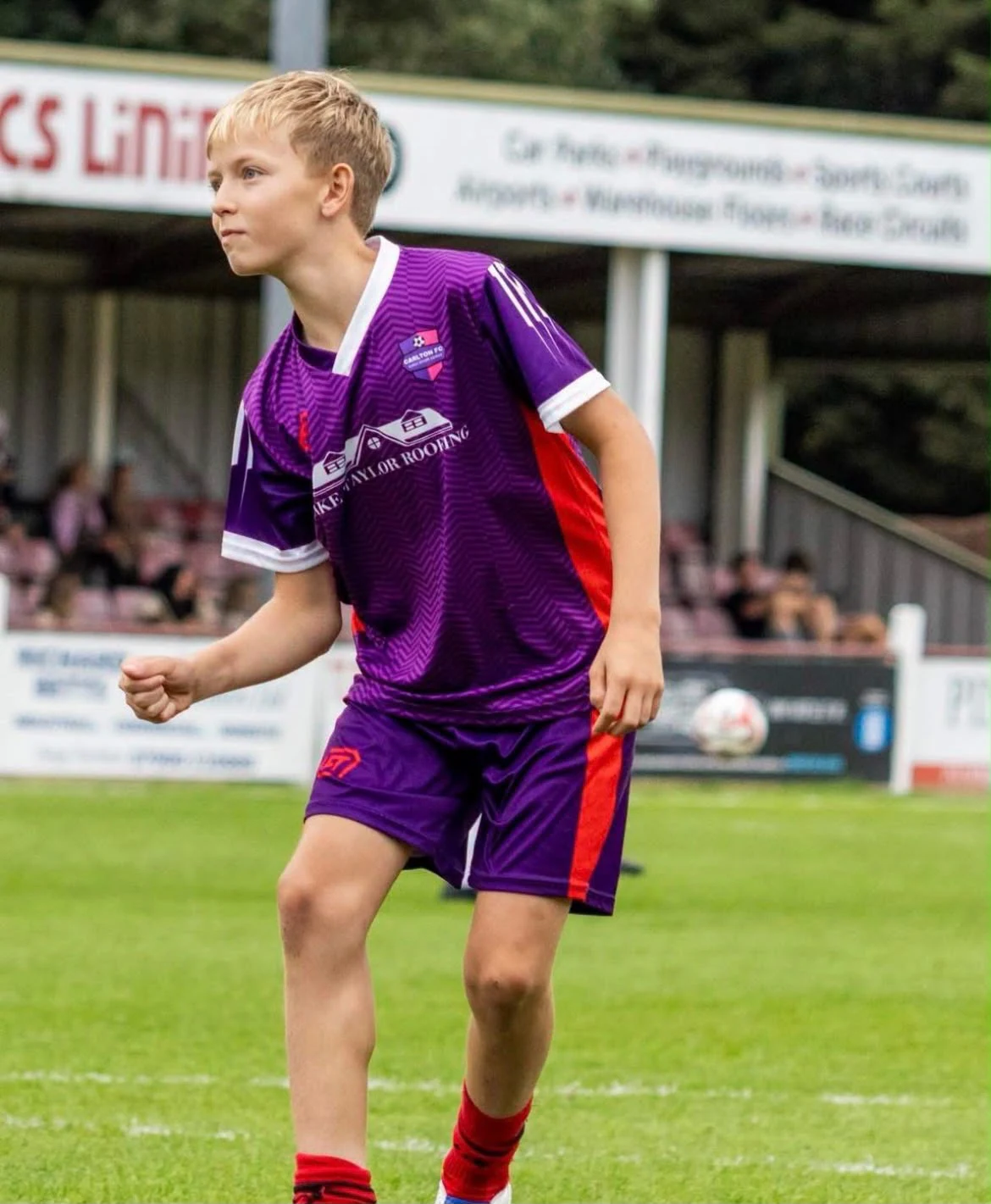 Young Carlton FC player wearing the club's purple FTACT match kit on the pitch