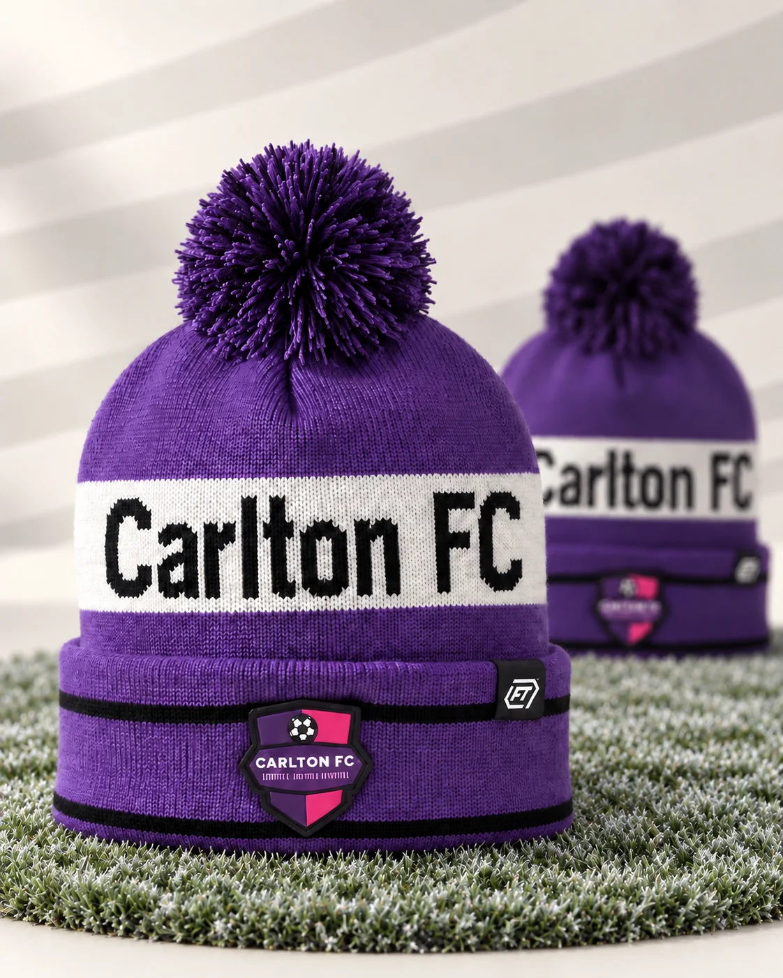 Purple Carlton FC bobble hats resting on frost-covered football turf