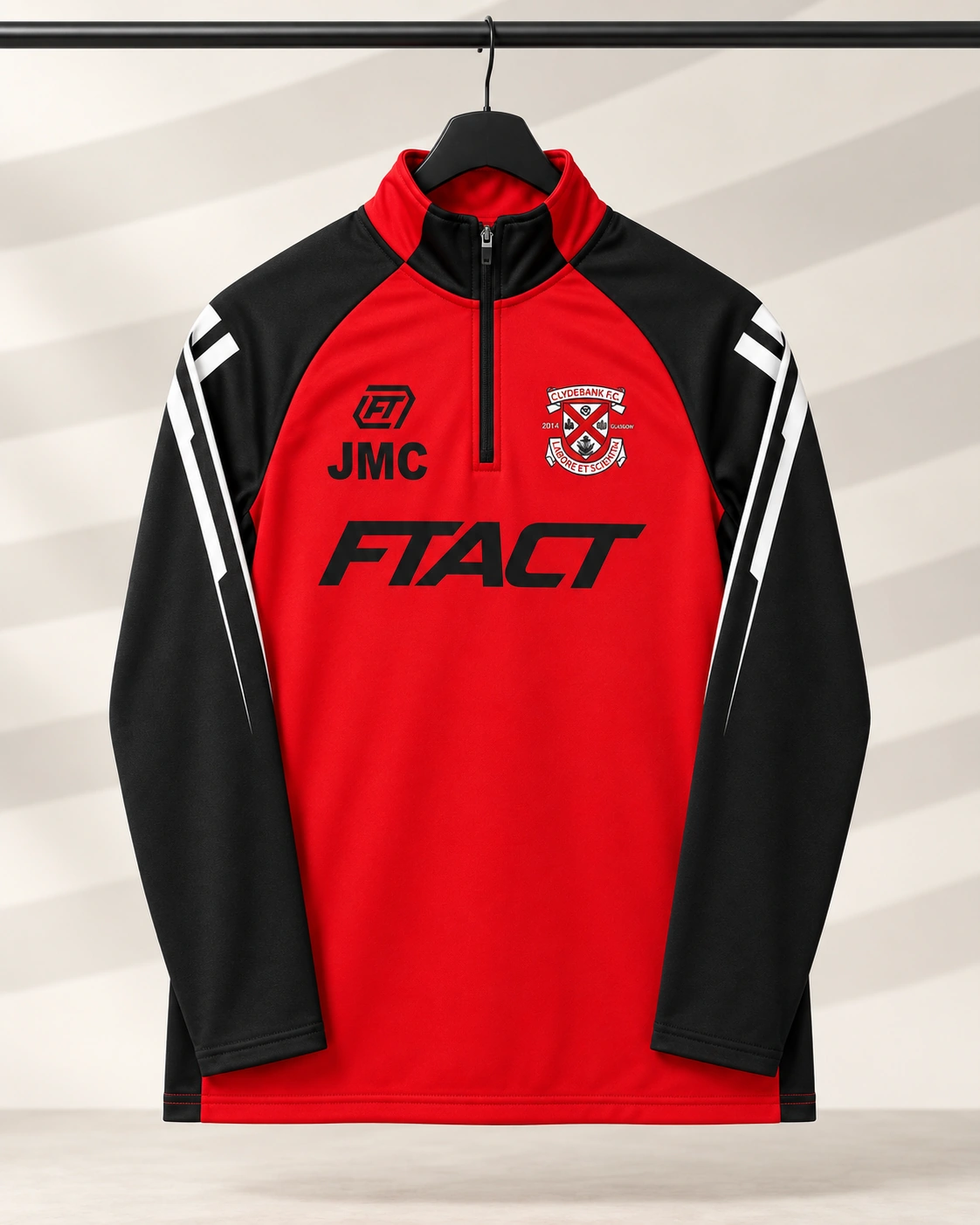 Red and black Clydebank quarter zip hanging neatly in a light studio